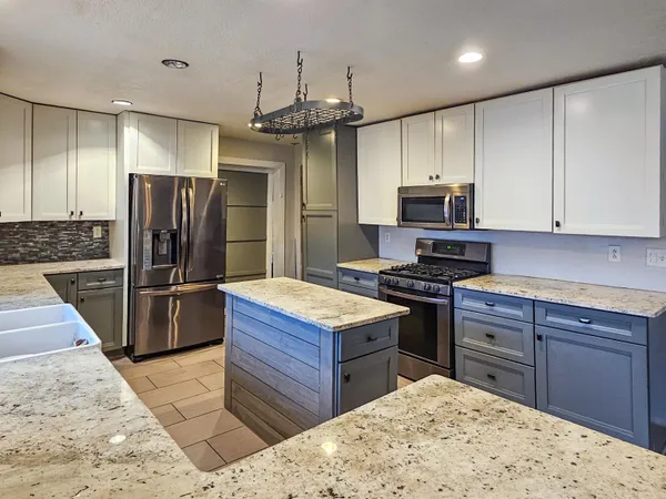 a kitchen with stainless steel appliances granite countertop a sink stove and refrigerator