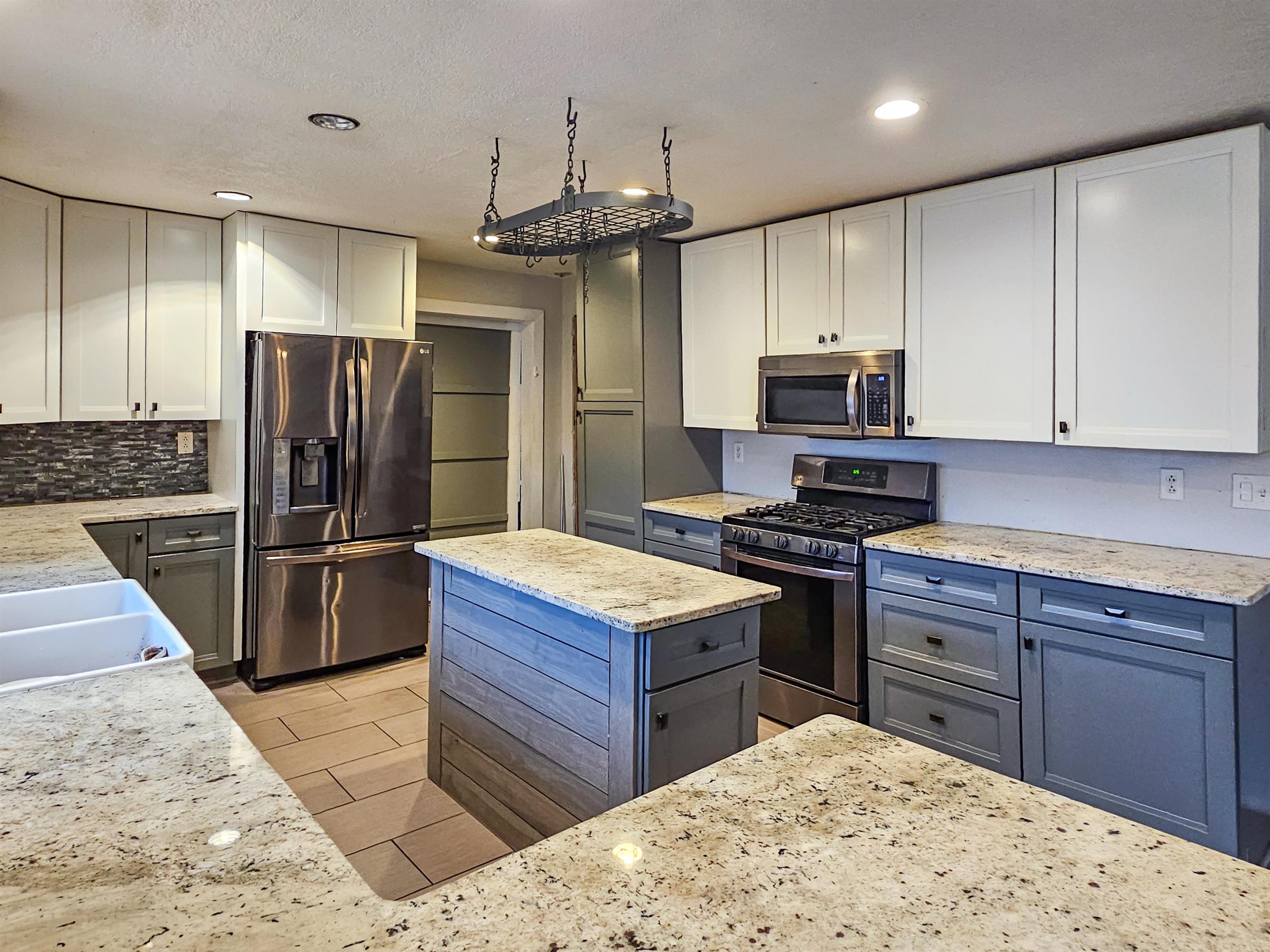 10582 Atwood Road Roscoe, IL 61073 - Photo 9 of 27 a kitchen with stainless steel appliances kitchen island granite countertop a refrigerator and a stove top oven