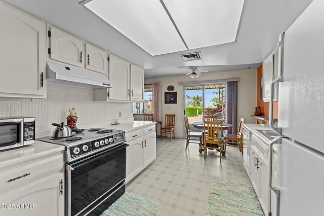 a kitchen with stainless steel appliances granite countertop a stove refrigerator and cabinets