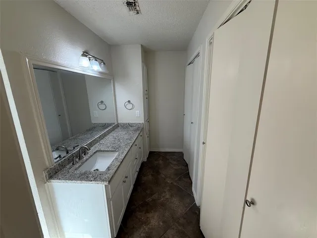a bathroom with a granite countertop sink a toilet and a mirror