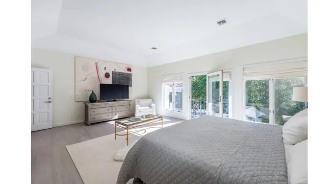 a living room with furniture a flat screen tv and a large window