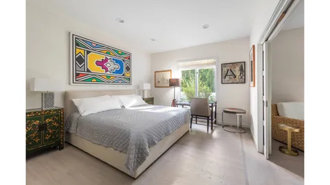 a bedroom with a bed and a painting on the wall