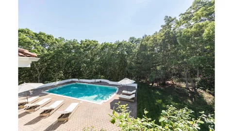 a view of a swimming pool and trees in the background