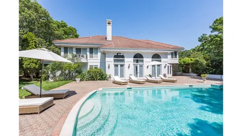 a view of a house with swimming pool and sitting area