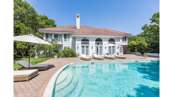 a view of a house with swimming pool and sitting area