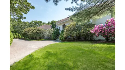 a view of a garden with a lot of flower plants and wooden fence