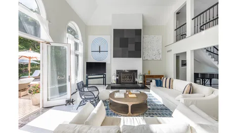 a living room with furniture a fireplace and a large window