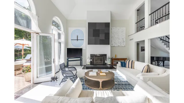 a living room with furniture a fireplace and a large window