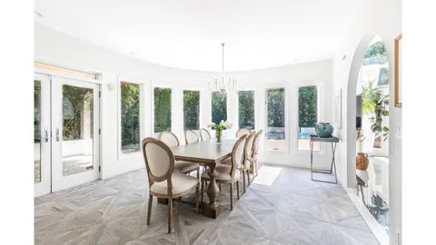 a dining room with furniture water view and a floor to ceiling window