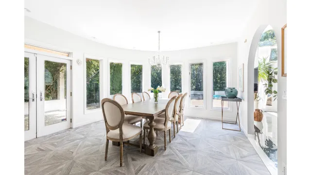 a dining room with furniture water view and a floor to ceiling window