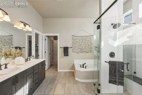 a spacious bathroom with a double vanity sink toilet mirror and shower