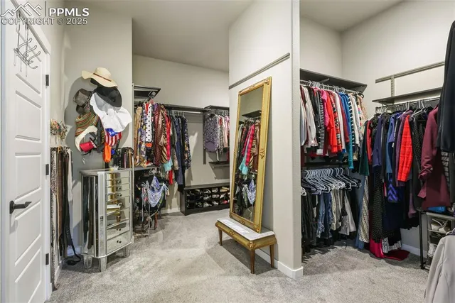 a view of walk in closet with clothes