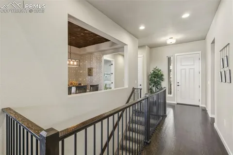 a view of a hallway with wooden floor and staircase
