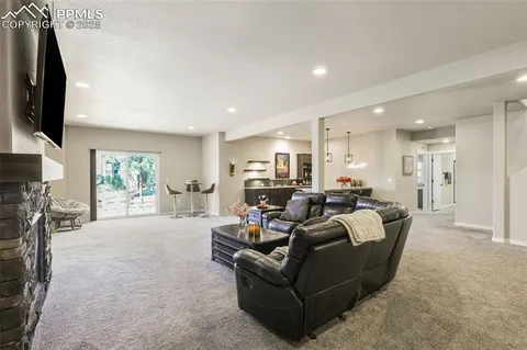 a living room with furniture a flat screen tv and a fireplace