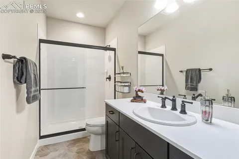 a bathroom with a sink toilet double vanity and shower
