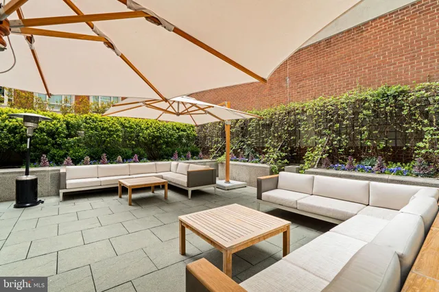 a view of a patio with couches table and chairs and potted plants