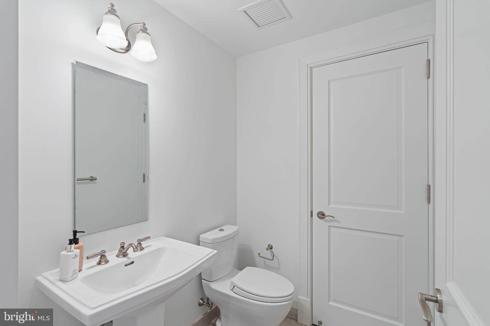 130 South 18th Street, Unit 501 Philadelphia, PA 19103 - Photo 4 of 43 a bathroom with a toilet a sink and mirror