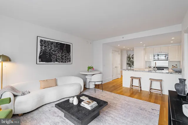 a kitchen with stainless steel appliances granite countertop a sink a stove a microwave a refrigerator a kitchen island and chairs