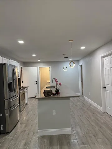 a view of a refrigerator in kitchen and windows