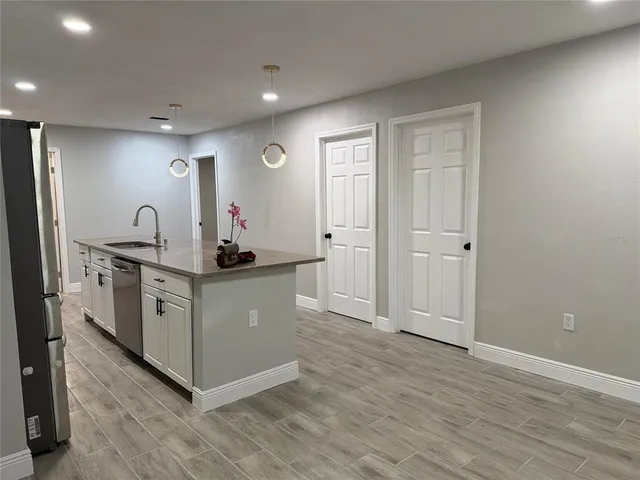 a kitchen with white cabinets and sink