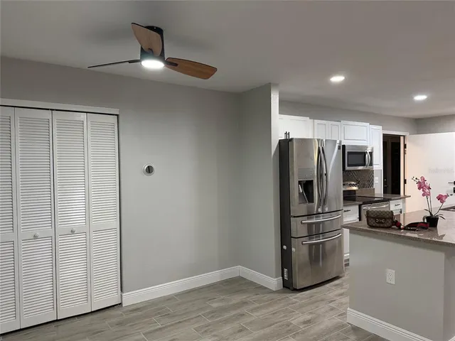 a kitchen with stainless steel appliances a refrigerator and wooden floor