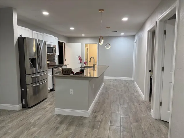 a view of kitchen with refrigerator microwave and wooden floor