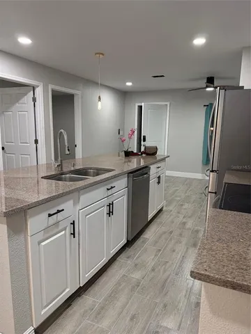 a kitchen with stainless steel appliances granite countertop a sink stove and refrigerator