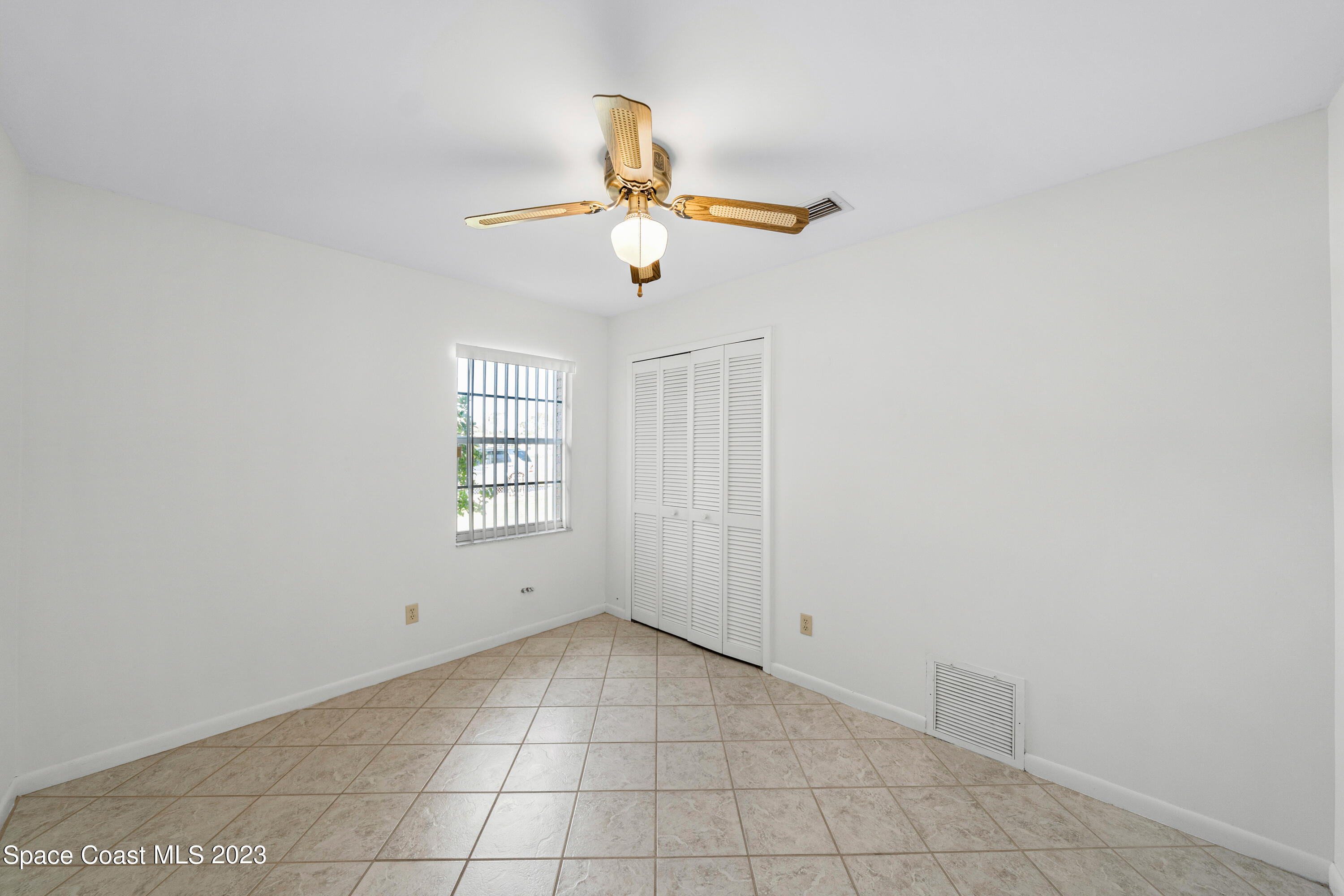 7746 Mango Grove Avenue Melbourne, FL 32904 - Photo 13 of 21 a view of an empty room with window and chandelier fan