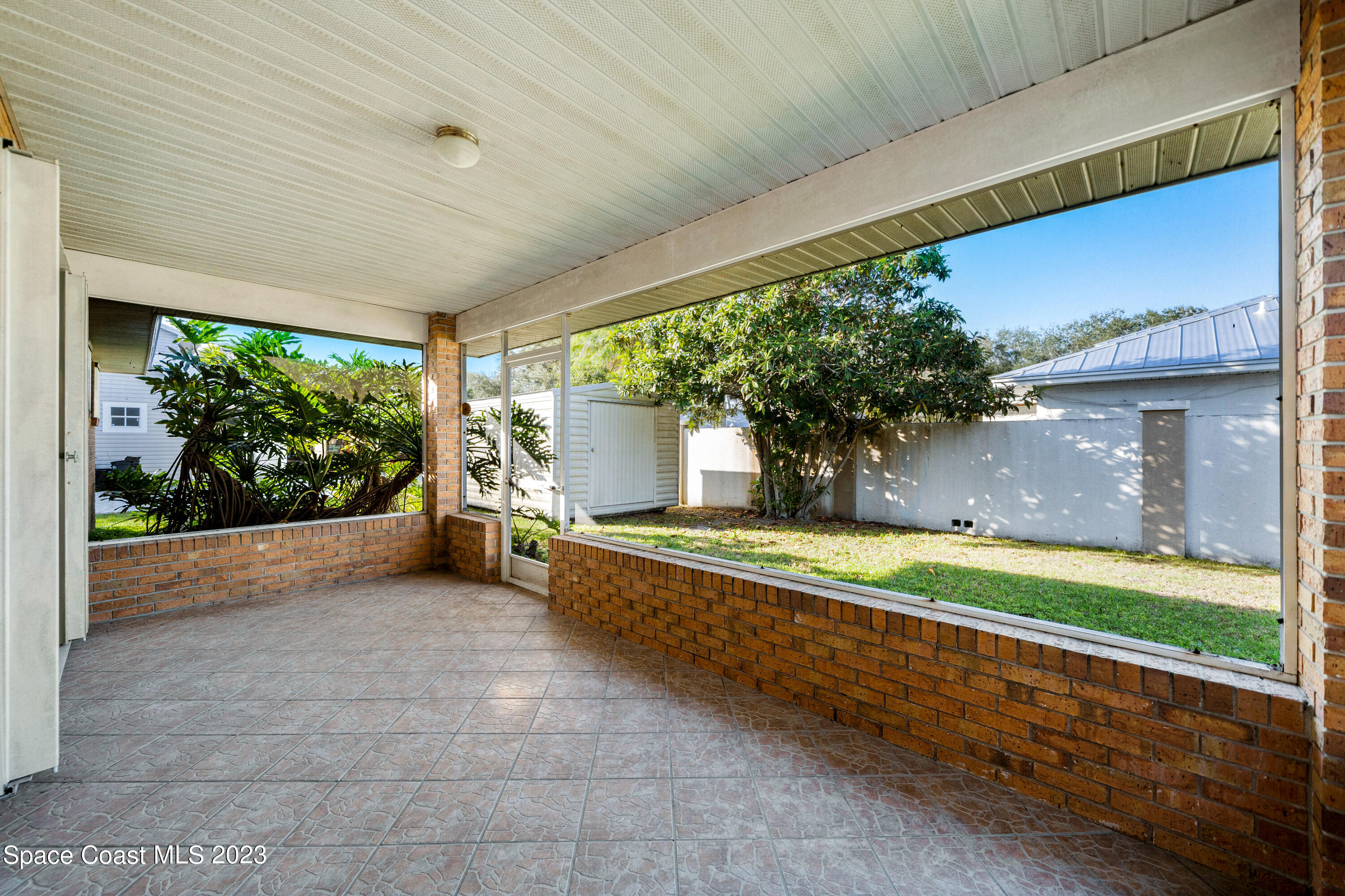 7746 Mango Grove Avenue Melbourne, FL 32904 - Photo 18 of 21 a view of a backyard with large trees and a large tree