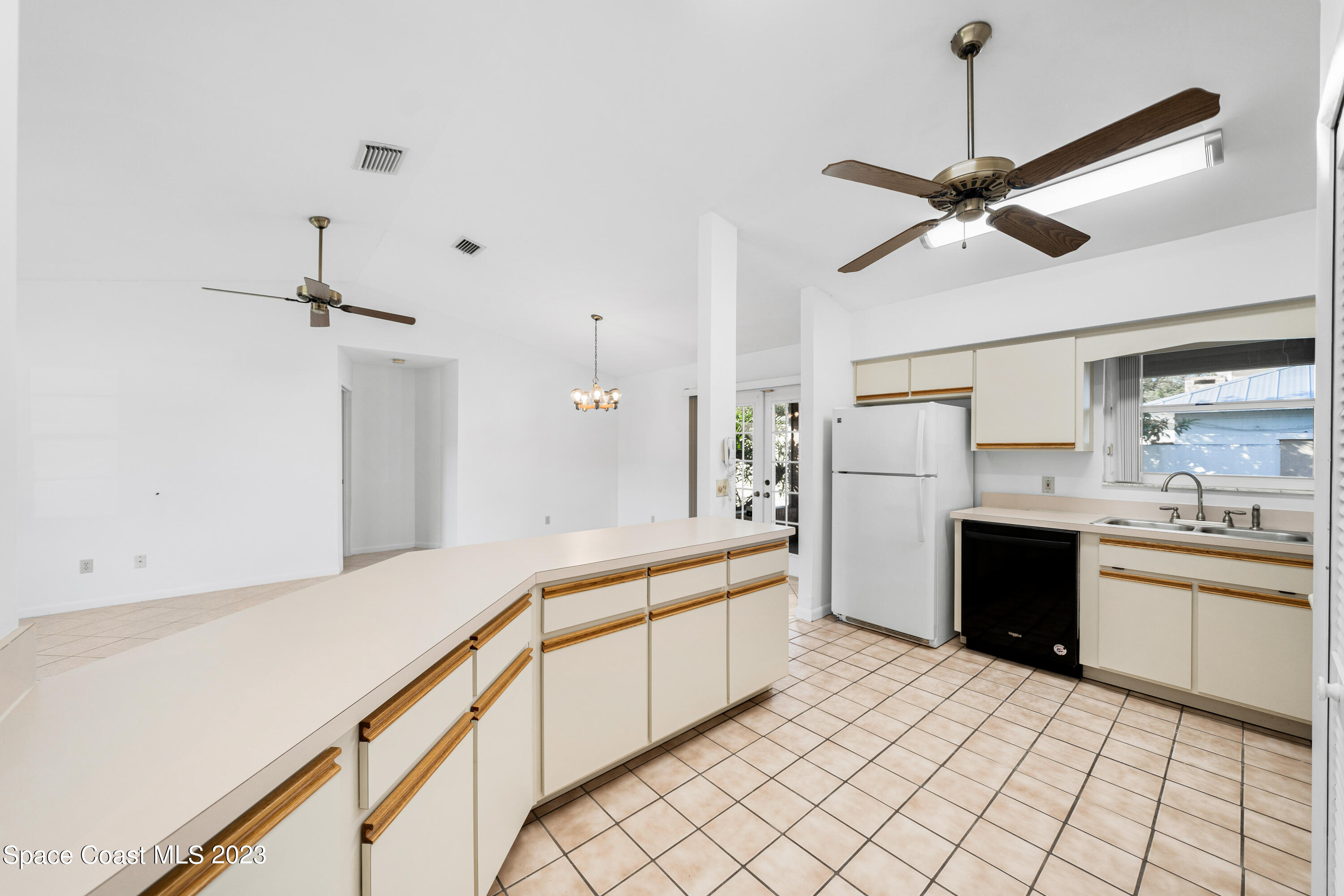 7746 Mango Grove Avenue Melbourne, FL 32904 - Photo 7 of 21 a large white kitchen with cabinets and stainless steel appliances