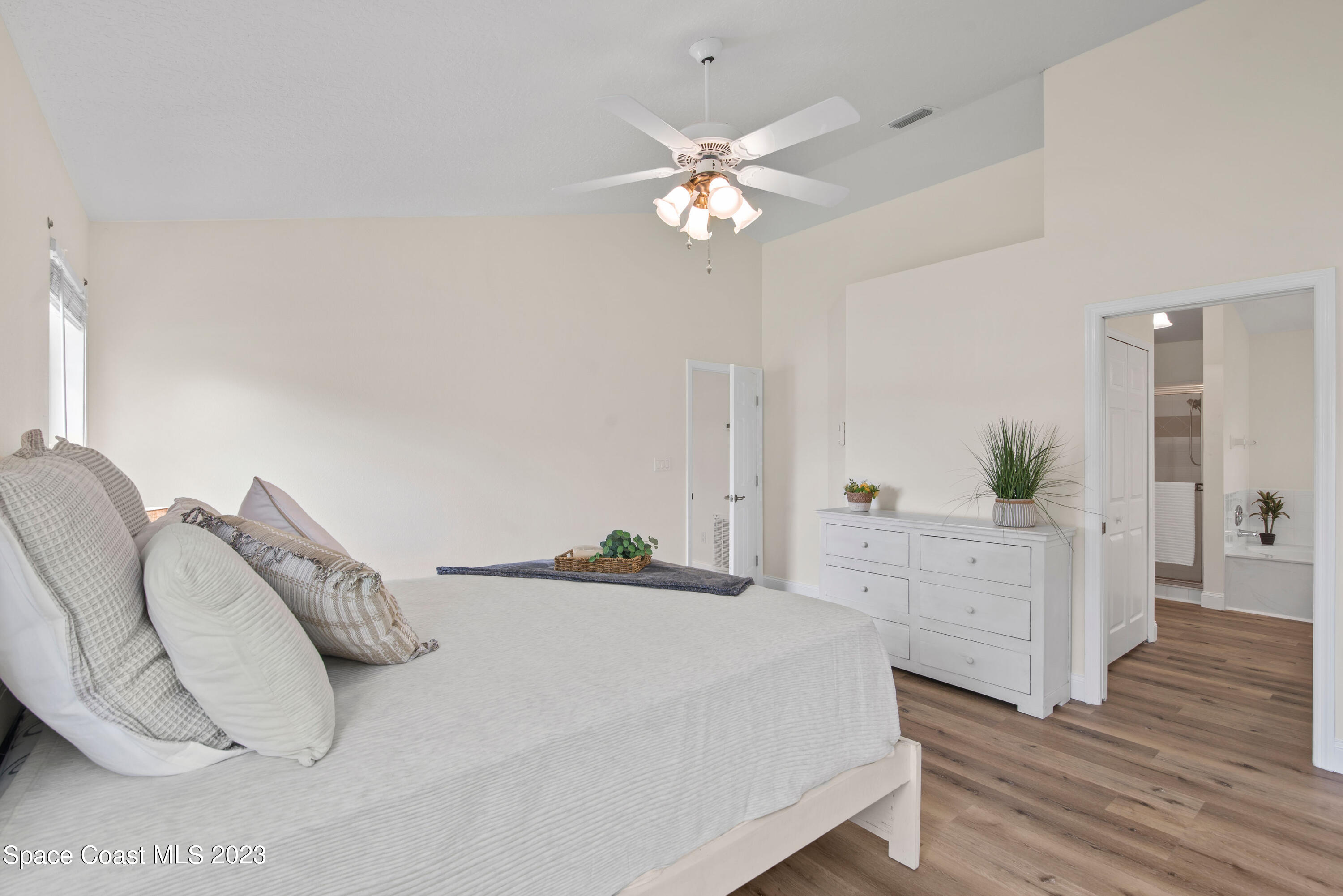 3360 Holly Springs Road Melbourne, FL 32934 - Photo 24 of 42 a bedroom with a bed and a chandelier