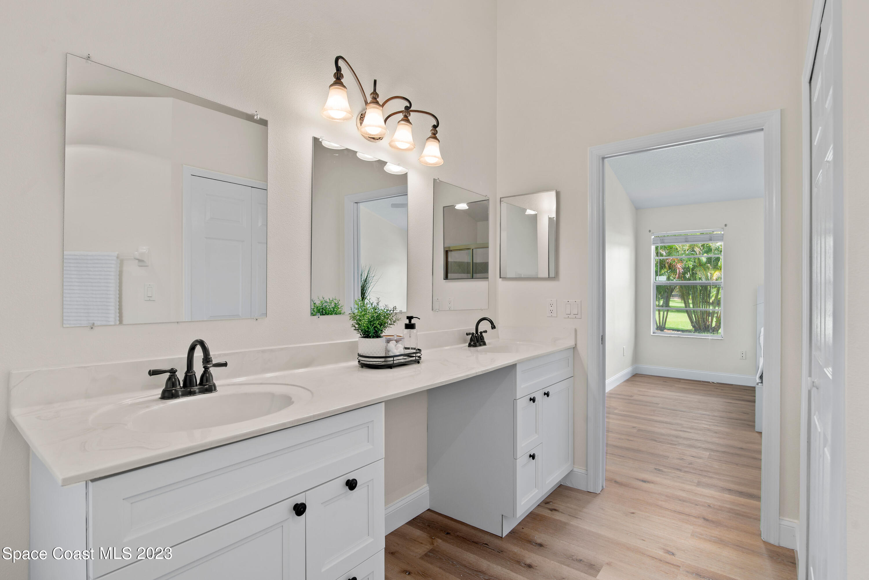 3360 Holly Springs Road Melbourne, FL 32934 - Photo 25 of 42 a bathroom with a double vanity sink and mirror