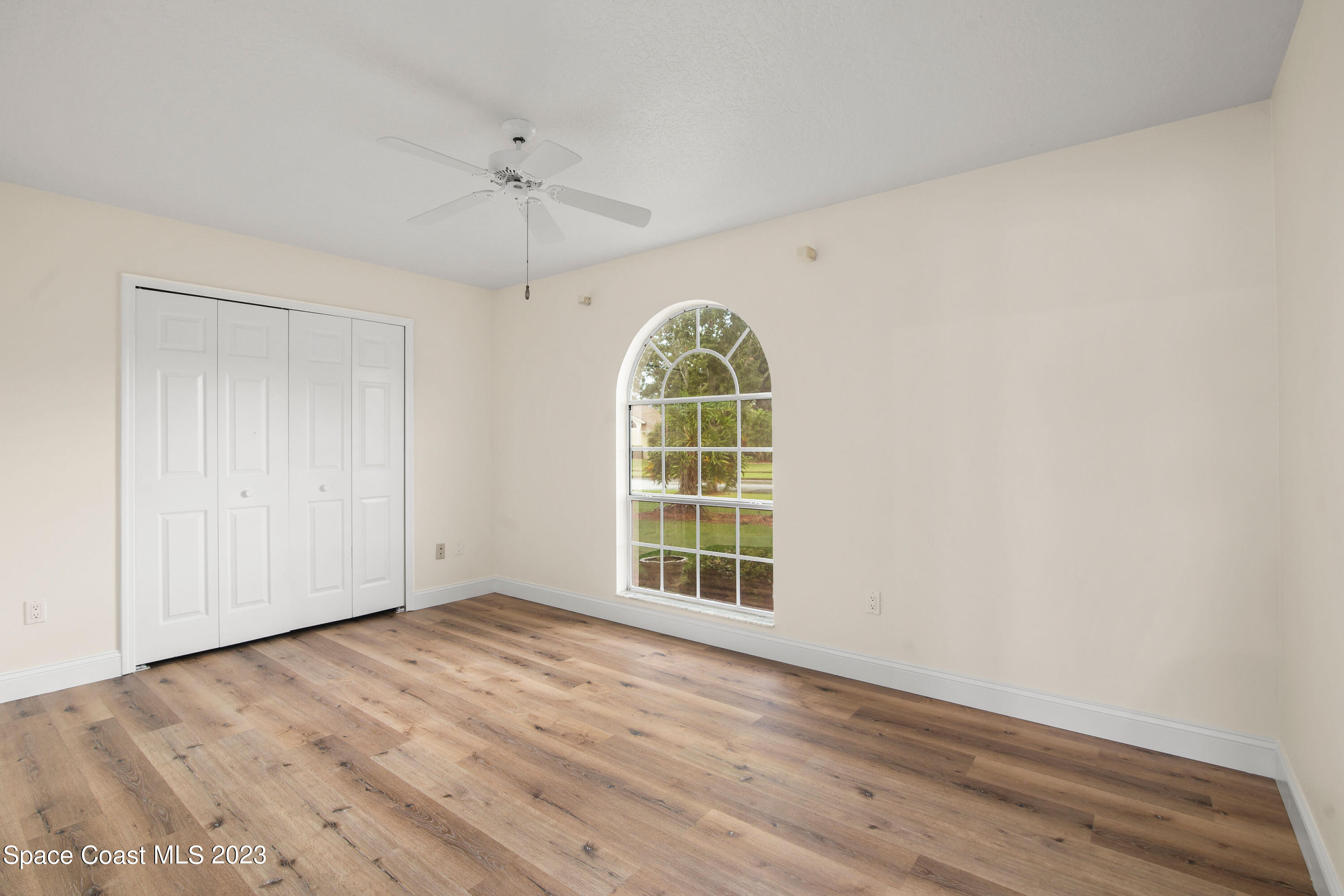 3360 Holly Springs Road Melbourne, FL 32934 - Photo 38 of 42 wooden floor in an empty room with a window