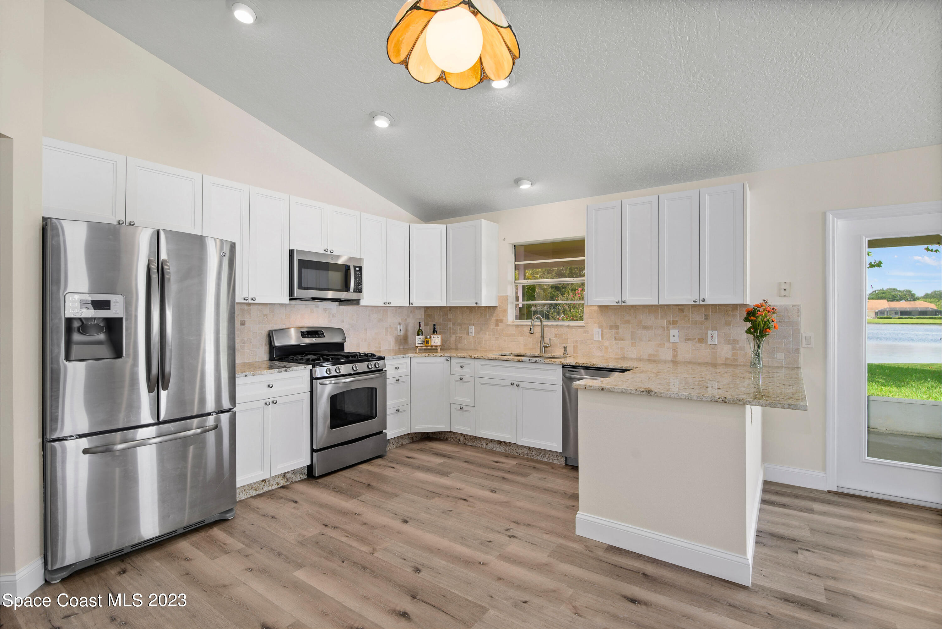 3360 Holly Springs Road Melbourne, FL 32934 - Photo 4 of 42 a kitchen with a refrigerator and a stove top oven