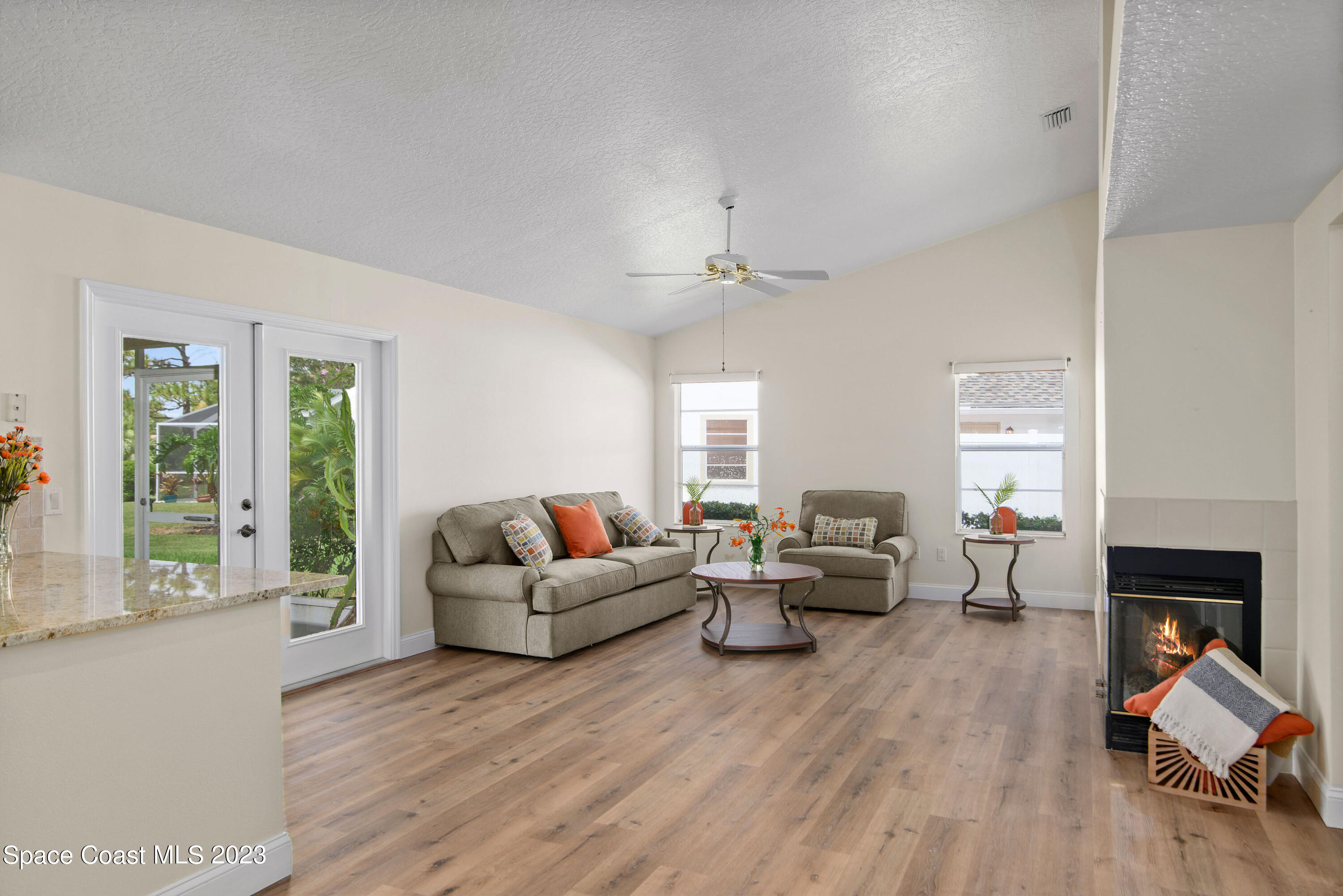 3360 Holly Springs Road Melbourne, FL 32934 - Photo 5 of 42 a living room with furniture and a fireplace