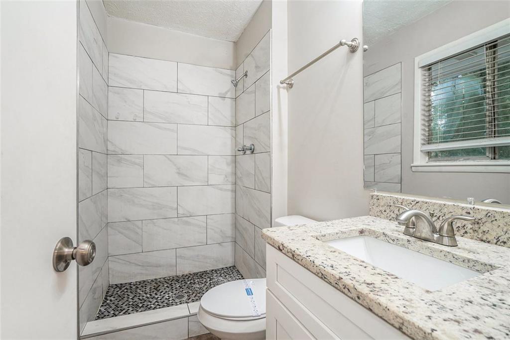 4442 Cedar Ridge Trail Stone Mountain, GA 30083 - Photo 9 of 15 a bathroom with a granite countertop sink a toilet a mirror and shower