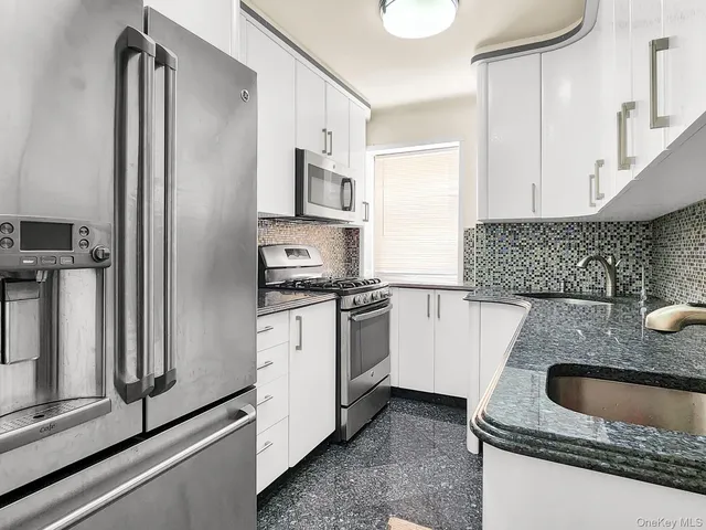 a kitchen with stainless steel appliances granite countertop a refrigerator and a sink