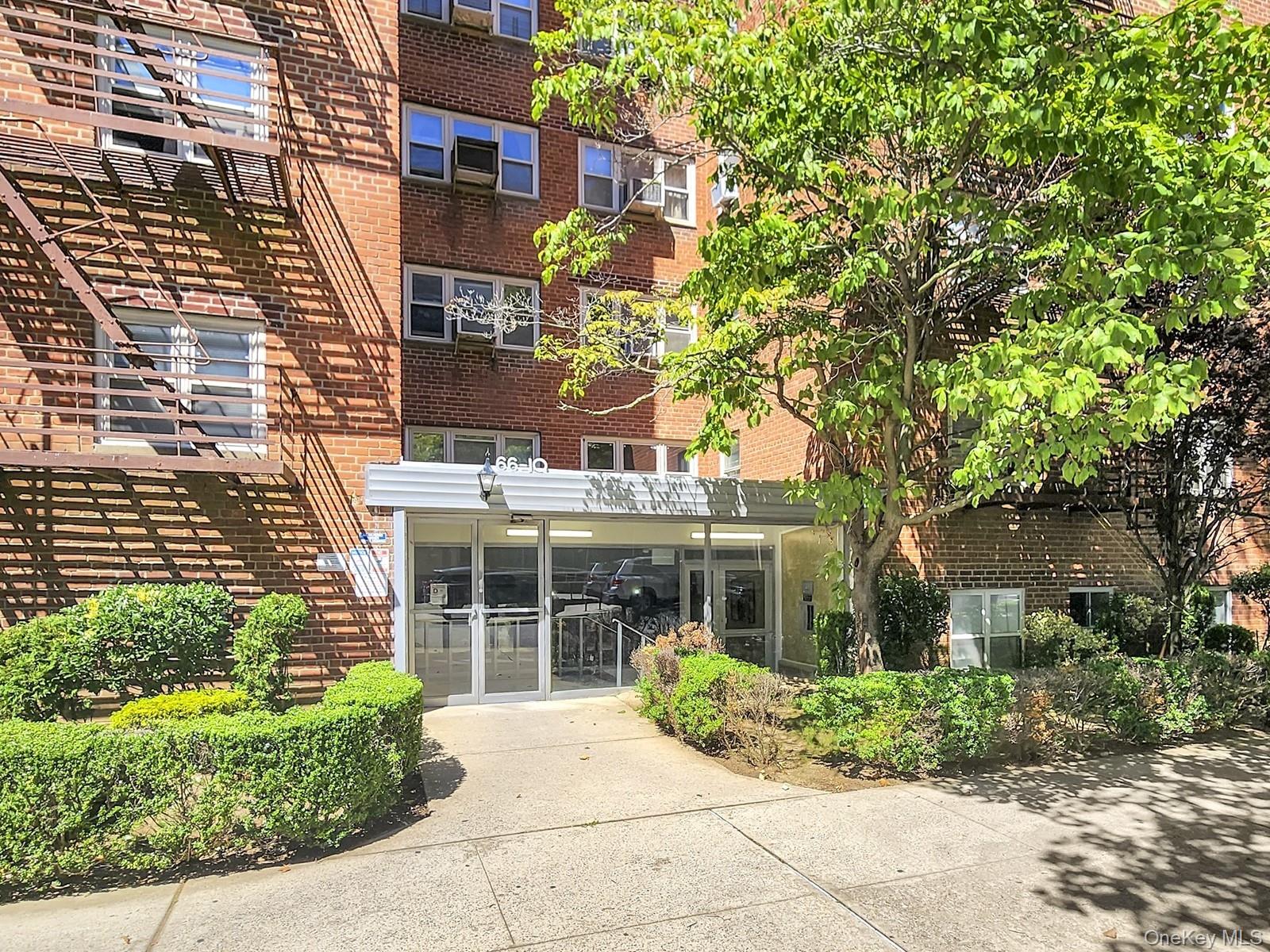 66-10 149th Street, Unit 1A Queens, NY 11367 - Photo 10 of 10 front view of a building and a garden
