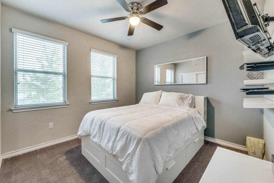5921 Lehman Way Austin, TX 78747 - Photo 17 of 25 Two well-lit windows and a ceiling fan enhance the comfort of this appealing bedroom.