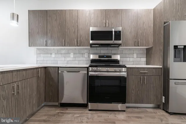 a kitchen with stainless steel appliances a stove a microwave and a sink