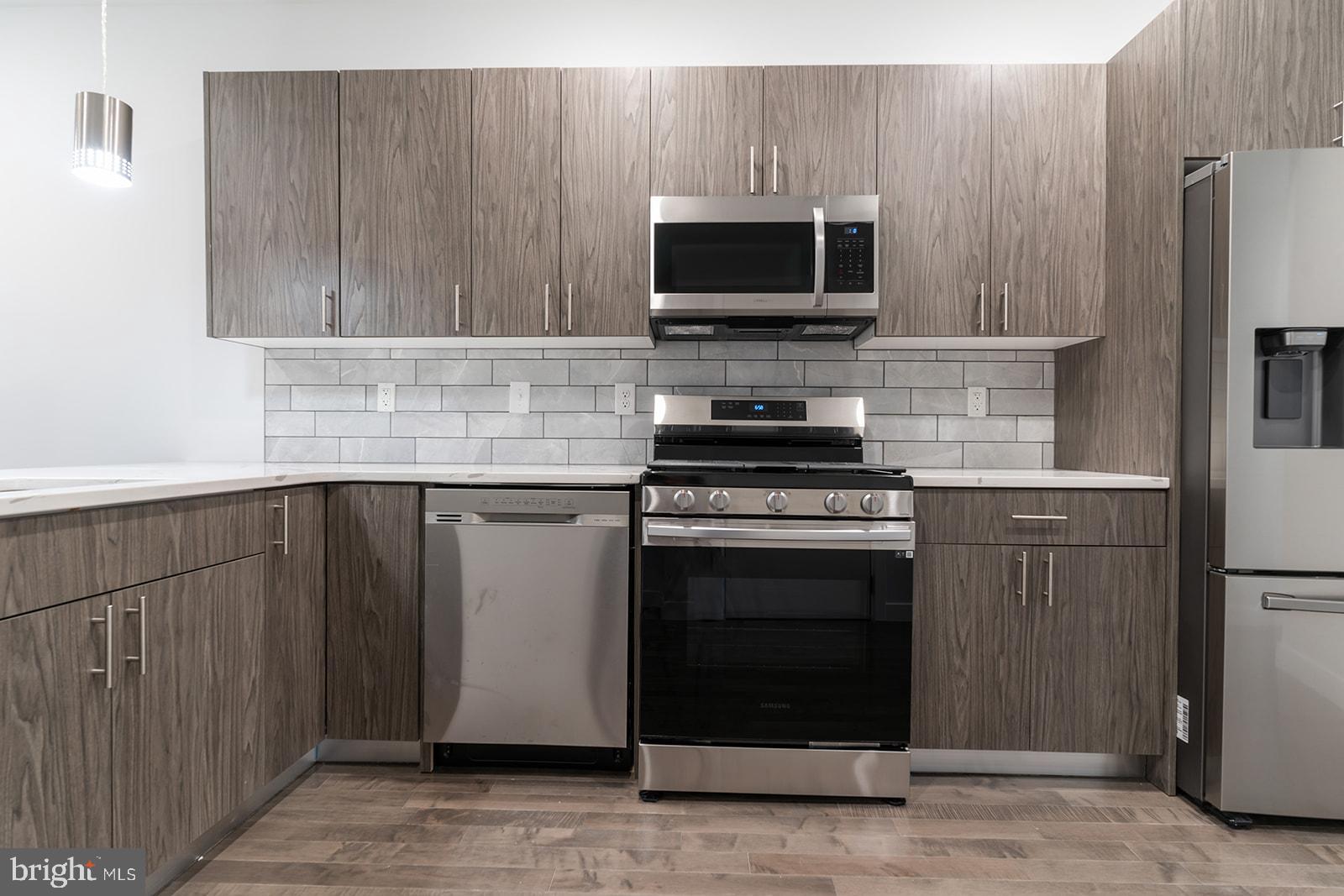 1947 North 7th Street, Unit 2 Philadelphia, PA 19122 - Photo 1 of 31 a kitchen with stainless steel appliances a stove a microwave and a sink
