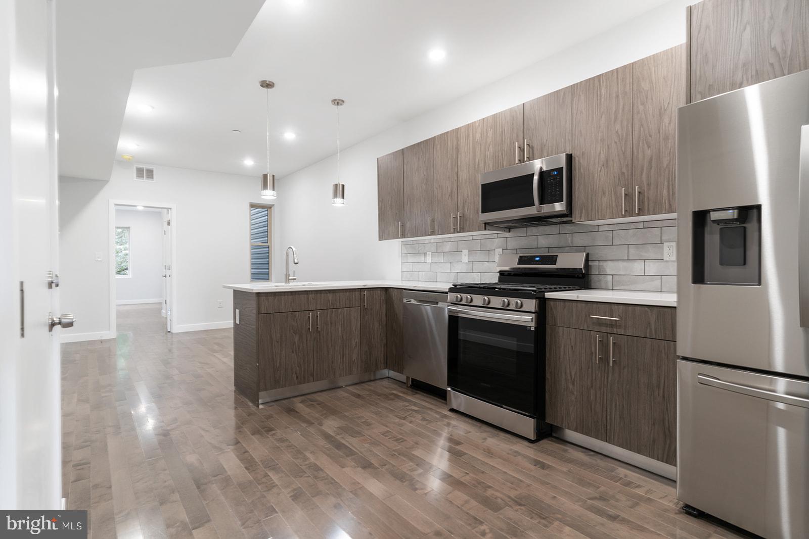 1947 North 7th Street, Unit 2 Philadelphia, PA 19122 - Photo 5 of 31 a kitchen with stainless steel appliances granite countertop a refrigerator a stove top oven a sink and dishwasher
