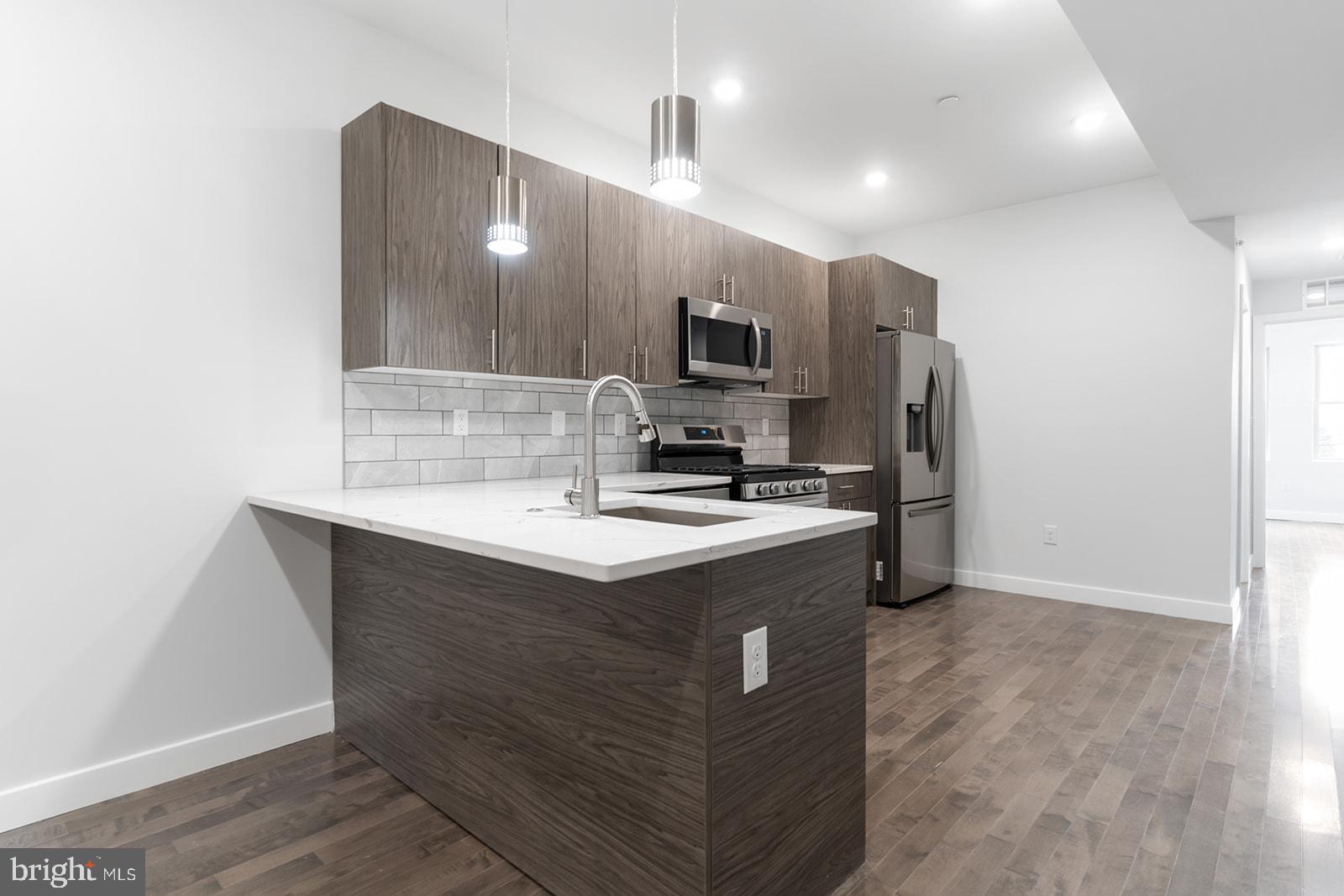 1947 North 7th Street, Unit 2 Philadelphia, PA 19122 - Photo 7 of 31 a kitchen with stainless steel appliances granite countertop a sink stove and refrigerator