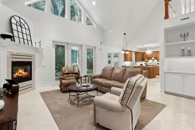 a view of a white house next to a yard with plants and trees
