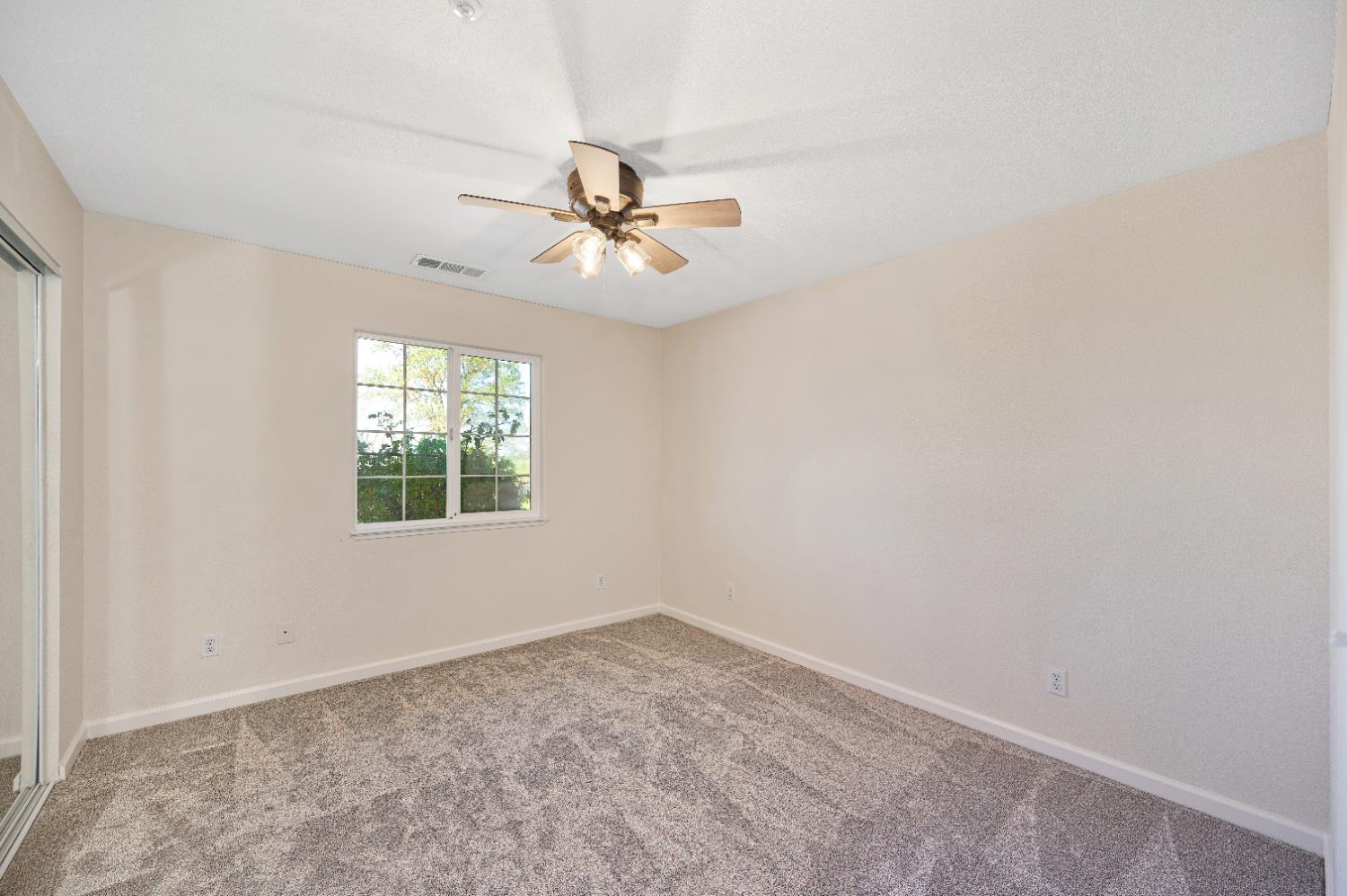 12260 Angle Road Herald, CA 95638 - Photo 16 of 43 an empty room with a window and ceiling fan
