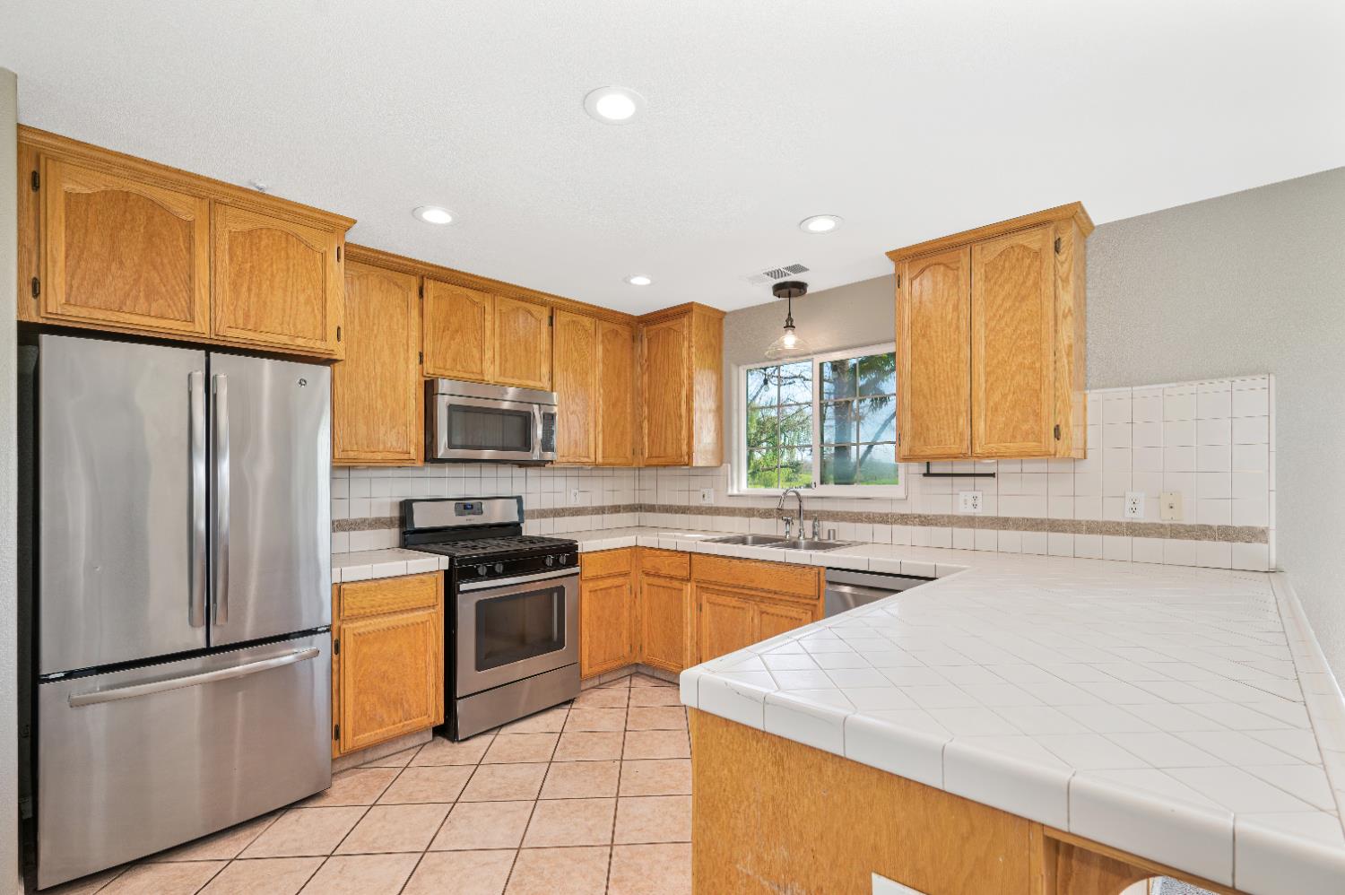 12260 Angle Road Herald, CA 95638 - Photo 6 of 43 a kitchen with stainless steel appliances granite countertop a refrigerator sink stove microwave and cabinets