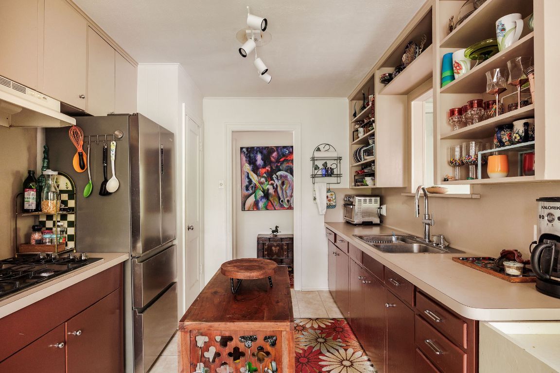 4201 Gregg Ward Lane Austin, TX 78744 - Photo 38 of 40 a kitchen with stainless steel appliances granite countertop a refrigerator and a sink