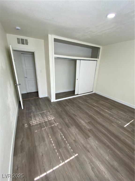 1711 Santa Paula Drive, Unit B Las Vegas, NV 89104 - Photo 14 of 17 Unfurnished bedroom with dark wood finished floors, a closet, and a textured ceiling