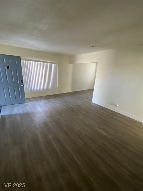 1711 Santa Paula Drive, Unit B Las Vegas, NV 89104 - Photo 5 of 17 Empty room with dark wood-type flooring and baseboards