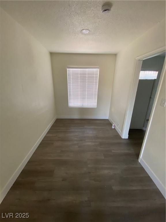 1711 Santa Paula Drive, Unit B Las Vegas, NV 89104 - Photo 6 of 17 Unfurnished dining area featuring a textured ceiling, dark wood-style flooring, and plenty of natural light
